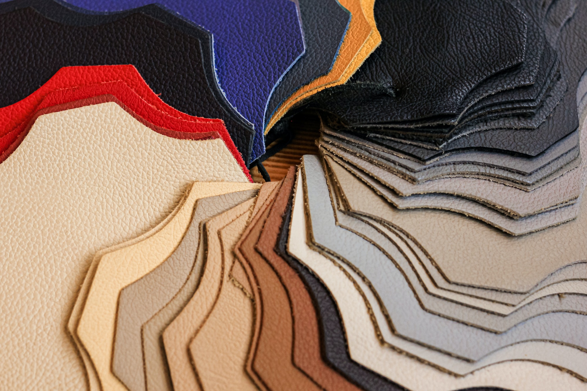 Samples of natural, textured, multi-colored leather. Top view. Industry fabric background.